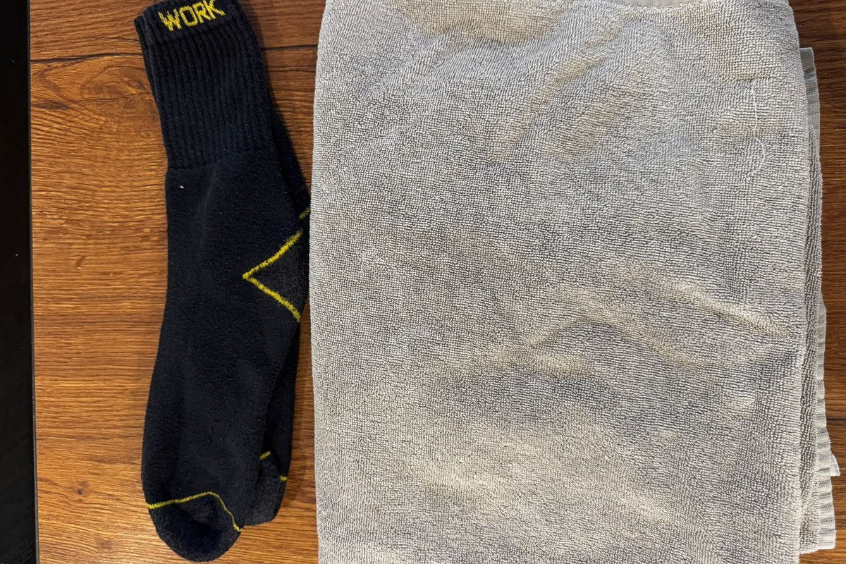 Dunkle Socken neben einem gefalteten grauen Handtuch
